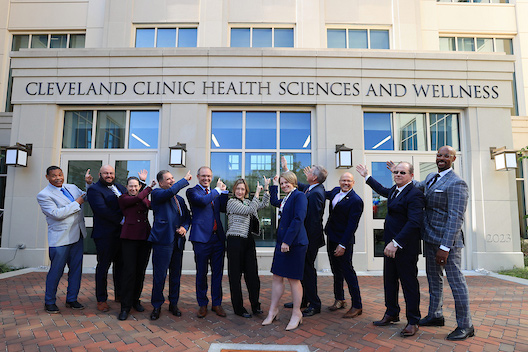 group of people standing in front of the Cleveland Clinic Health Sciences and Wellness building