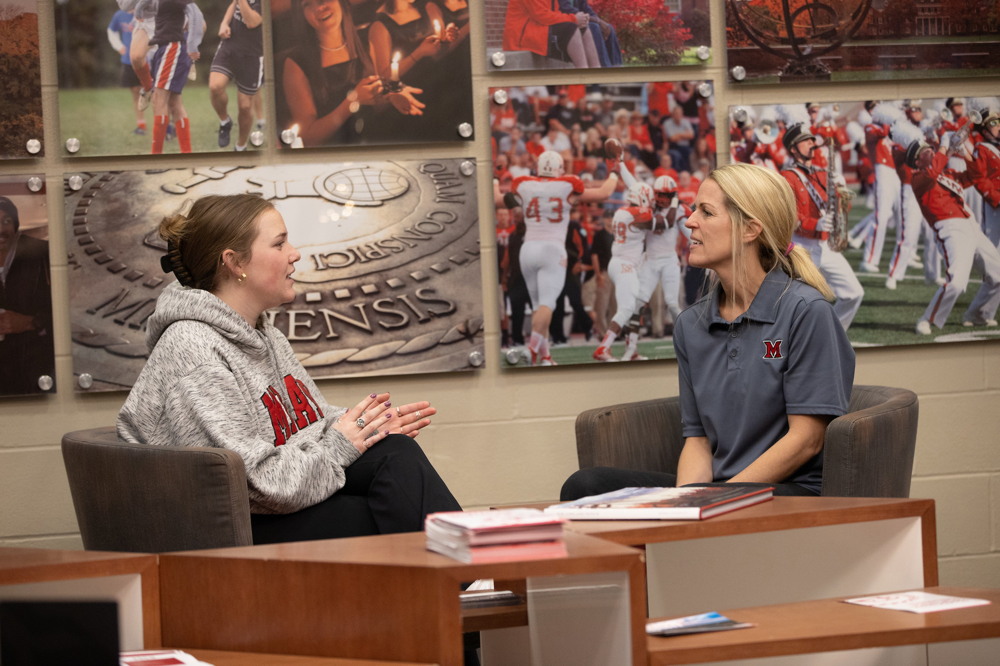 An SSC staff member speaks with a student in a lobby.