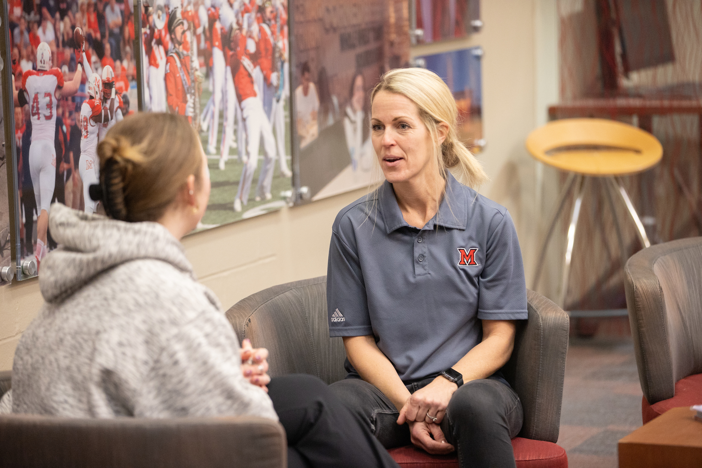 A Pathways advisor meets with a student in a lounge.