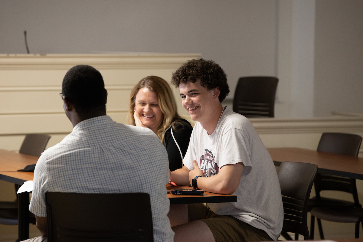 Two students speak with an advisor.