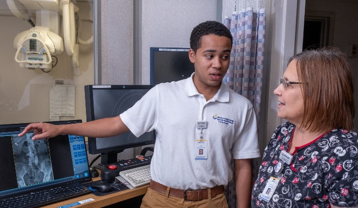 Nursing student working with a staff member during his internship