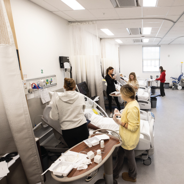 Clinical Health Sciences & Wellness Building nursing resource center with students working on the manikins.