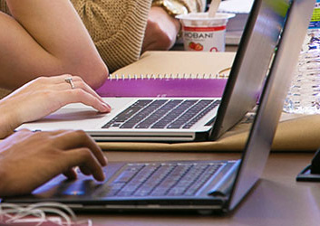 A pair of hands poised above a laptop keyboard