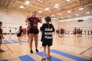 Student teaching youth to jump rope