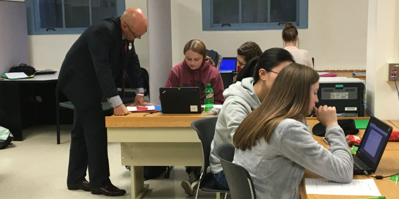 President Crawford talks with students in the classroom.