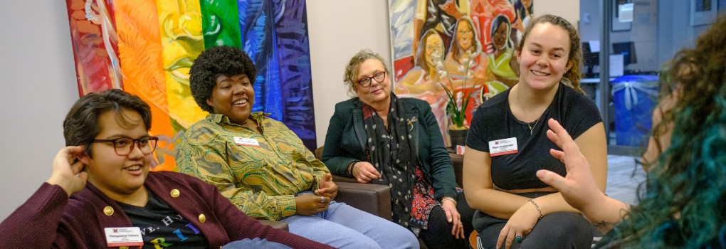 People sitting in a group smiling and talking.