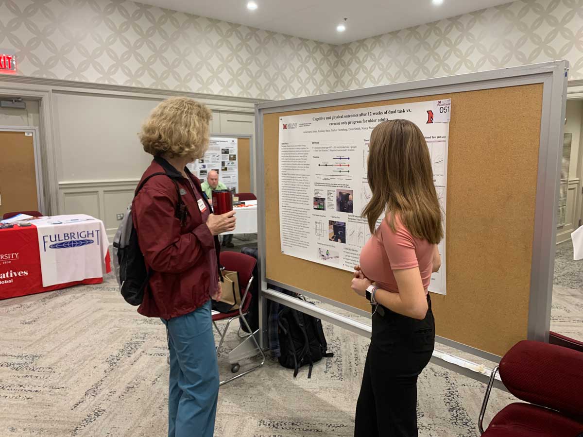 Helaine Alessio listing to a student present their undergraduate research topic.