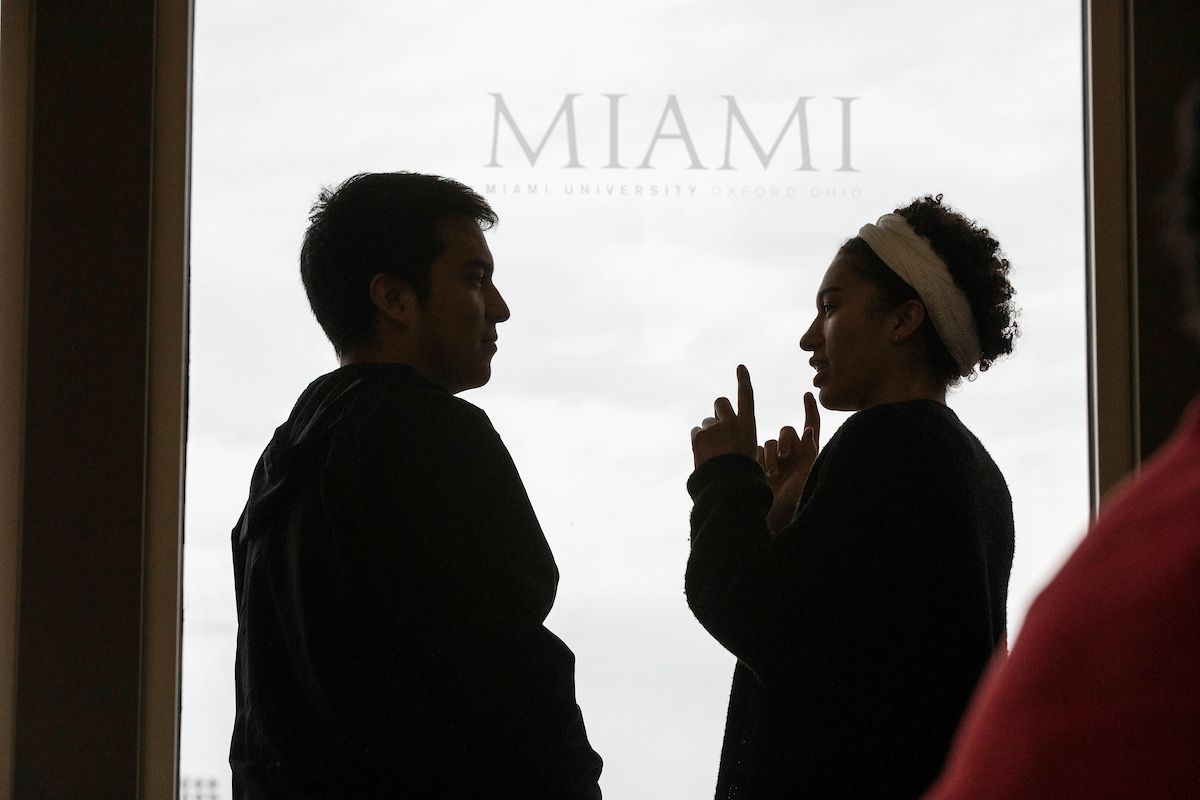 students standing in front of door with miami university etched in glass