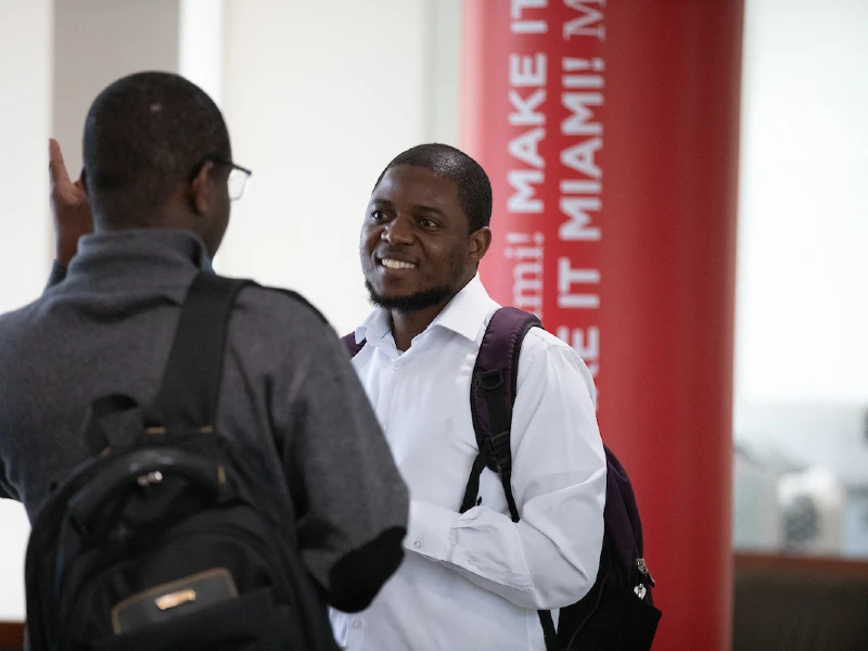 student talking to professor at event