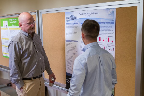 kevin bush talking with student at research forum