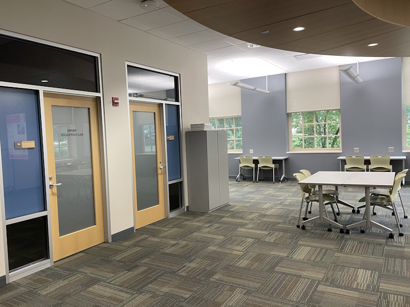 View of Sport Performance Lab at Miami University  with that includes a carpeted room with a file cabinet, desks and chairs, doors to interior rooms and two windows with lovely views of the campus.