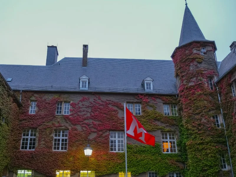 luxembourg chateau at dusk with lights on and miami flag flying in front of building