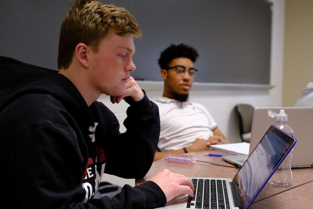 two students in classroom working on computer