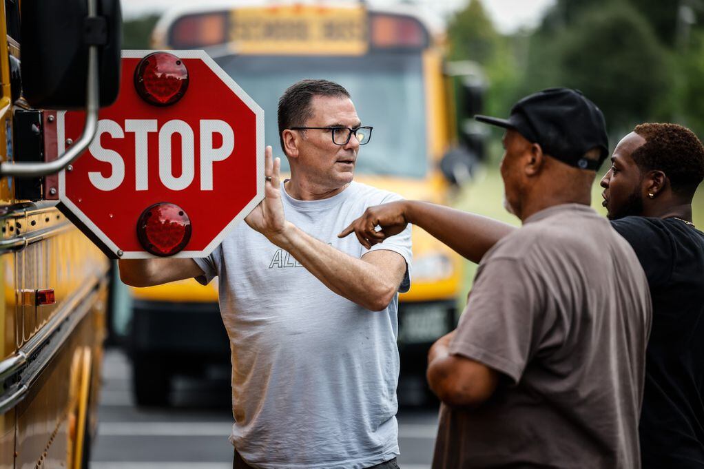 Dayton public schools bus drivers in training, from left, Tim Walden, Donald Mickler, and Darell Henderson go through a check-list of a school bus while training to be drivers at Welcome Stadium Tuesday August 9, 2022.