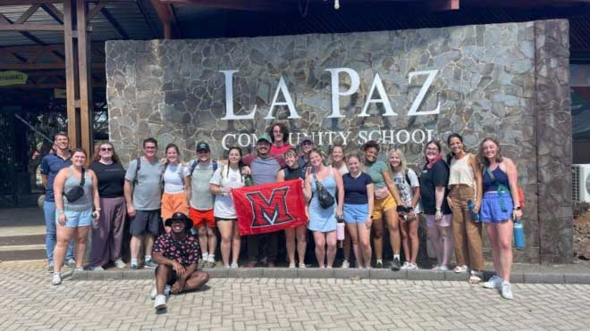 Brian Schultz and 18 Miami students in front of La Paz Community School in Costa Rica