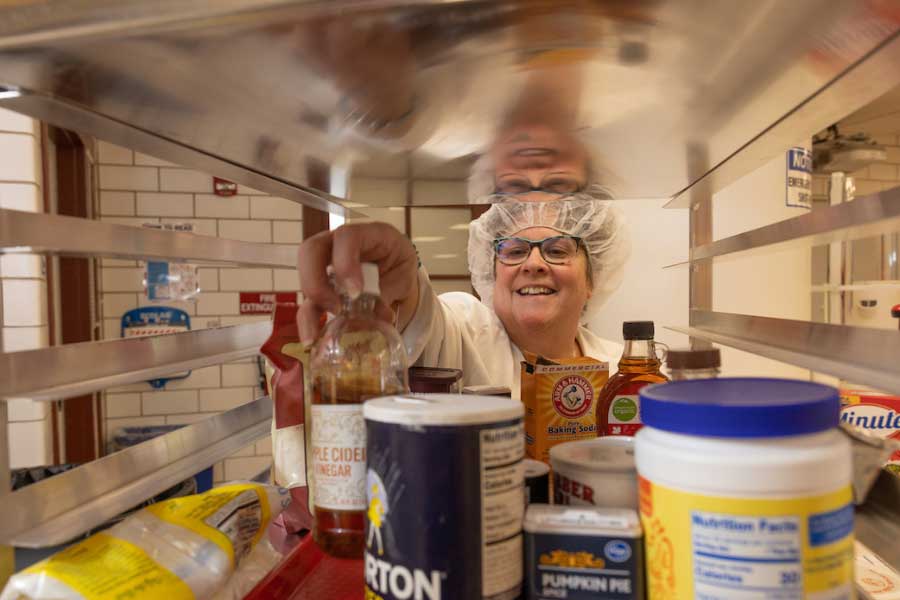 Nancy Parkinson reaching for a bottle of apple cider vinegar among other ingredients