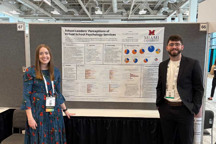 Lisa Roessner and P.J. McCallister in front of their poster