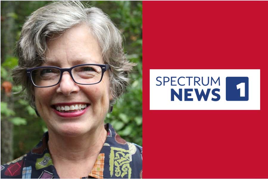 Kathleen Knight Abowitz smiling outdoors next to Spectrum News 1 logo on red background.