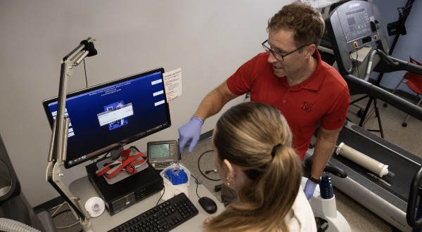 Kyle Timmerman, Interim Chair of KNH, works with a student in the exercise physiology lab
