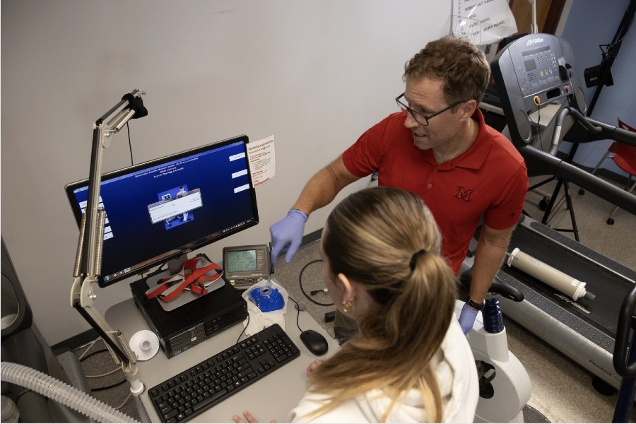 Kyle Timmerman, Interim Chair of KNH, works with a student in the exercise physiology lab
