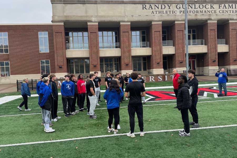 Miamisburg High School students gather outside on a practice football field before touring the Miami Athletics Performance and Development Center.