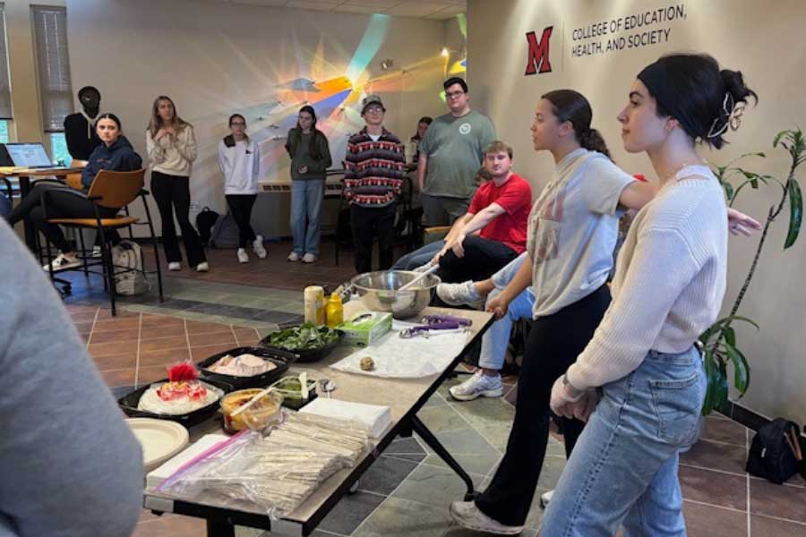 Students lead a hands-on cooking demo during an activity at the EHS Interprofessional Symposium.