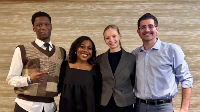 Toyon Embry, Sydnie Singleton, Giselle Pagliaro, and Brian Schultz posing together in a conference room.