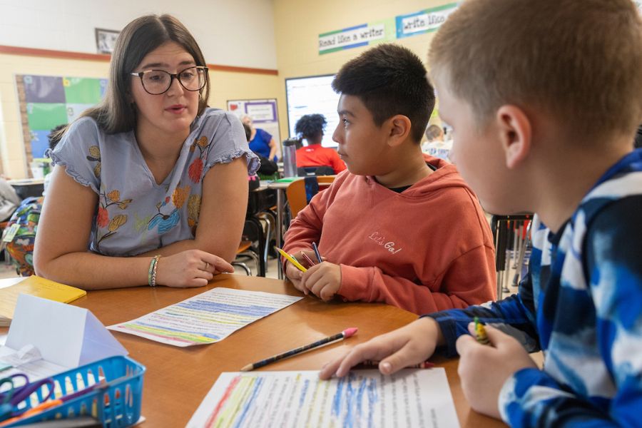 An EHS student teacher works through reading comprehension sheets with students at Hamilton City Schools.