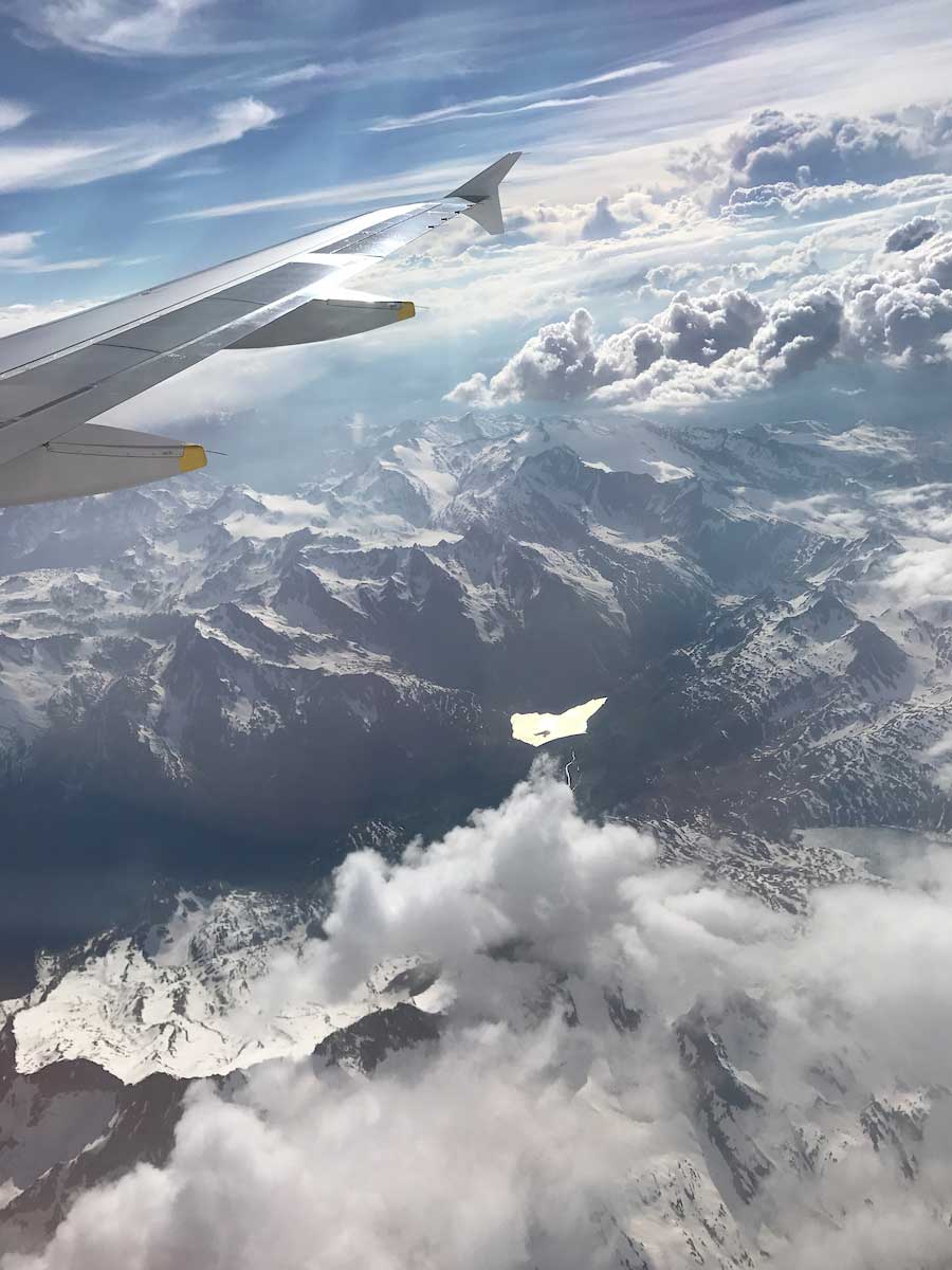 View from a plane flying above mountains and clouds