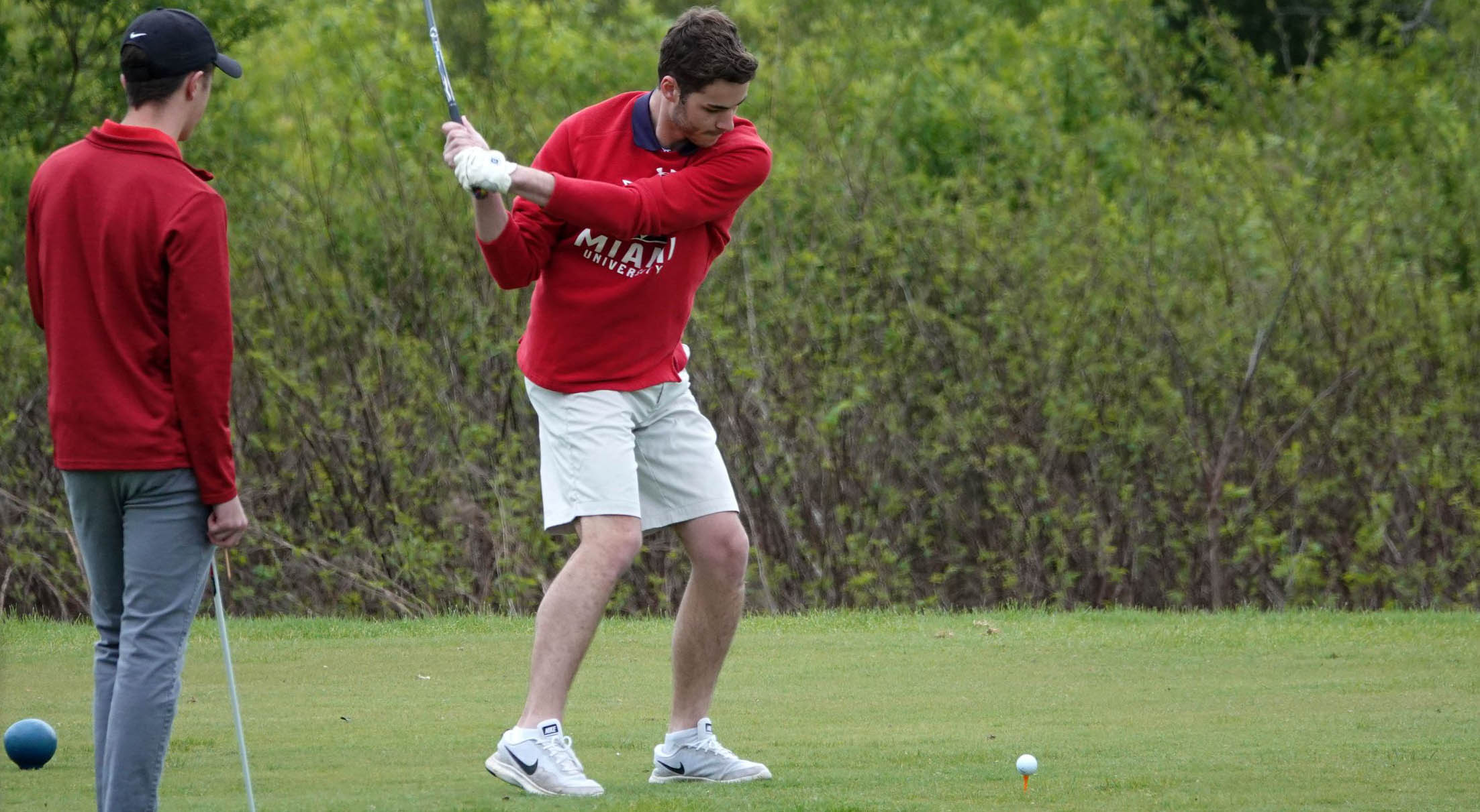 Golfer swinging at ball