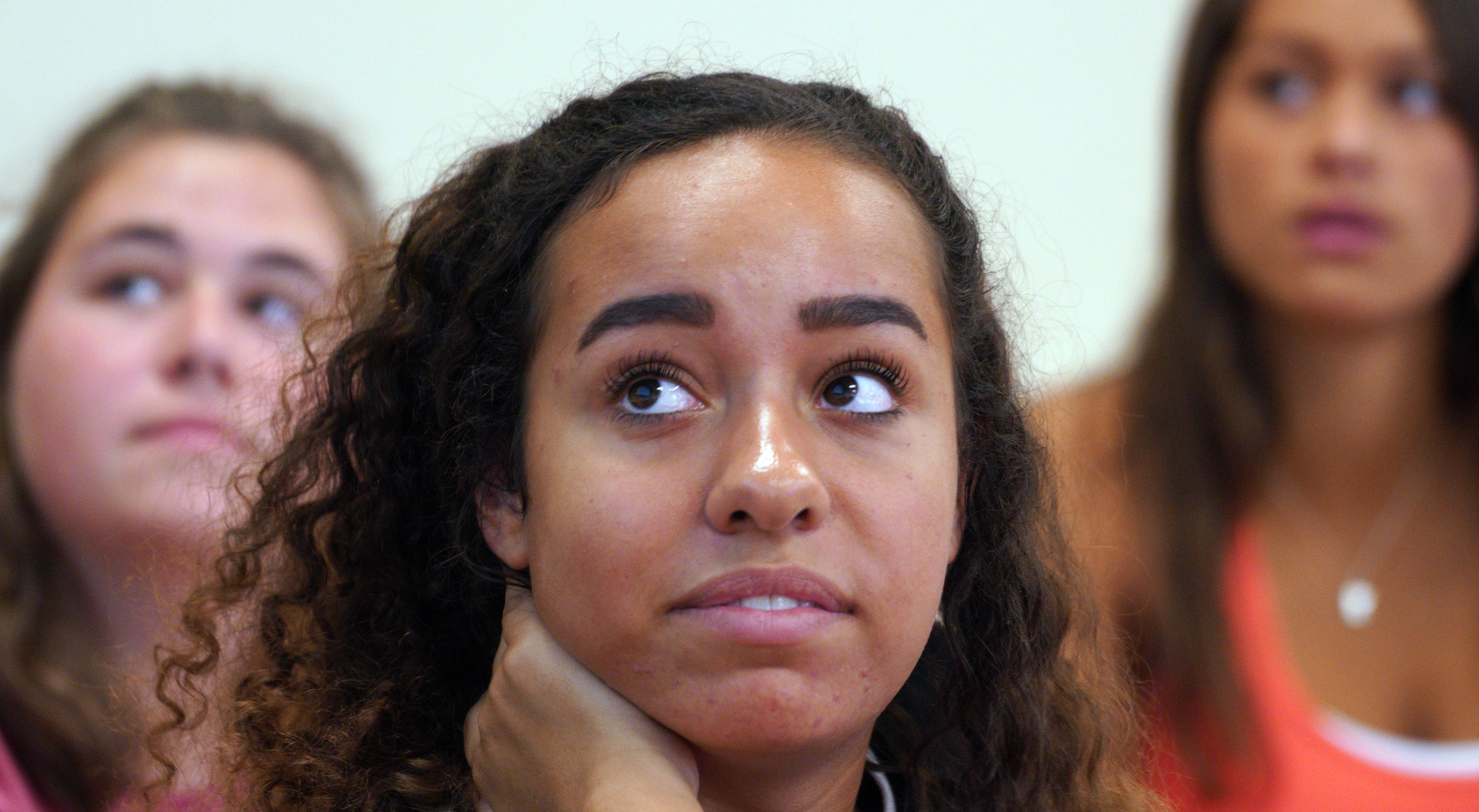 Student looks at whiteboard while Emily Akil asks questions