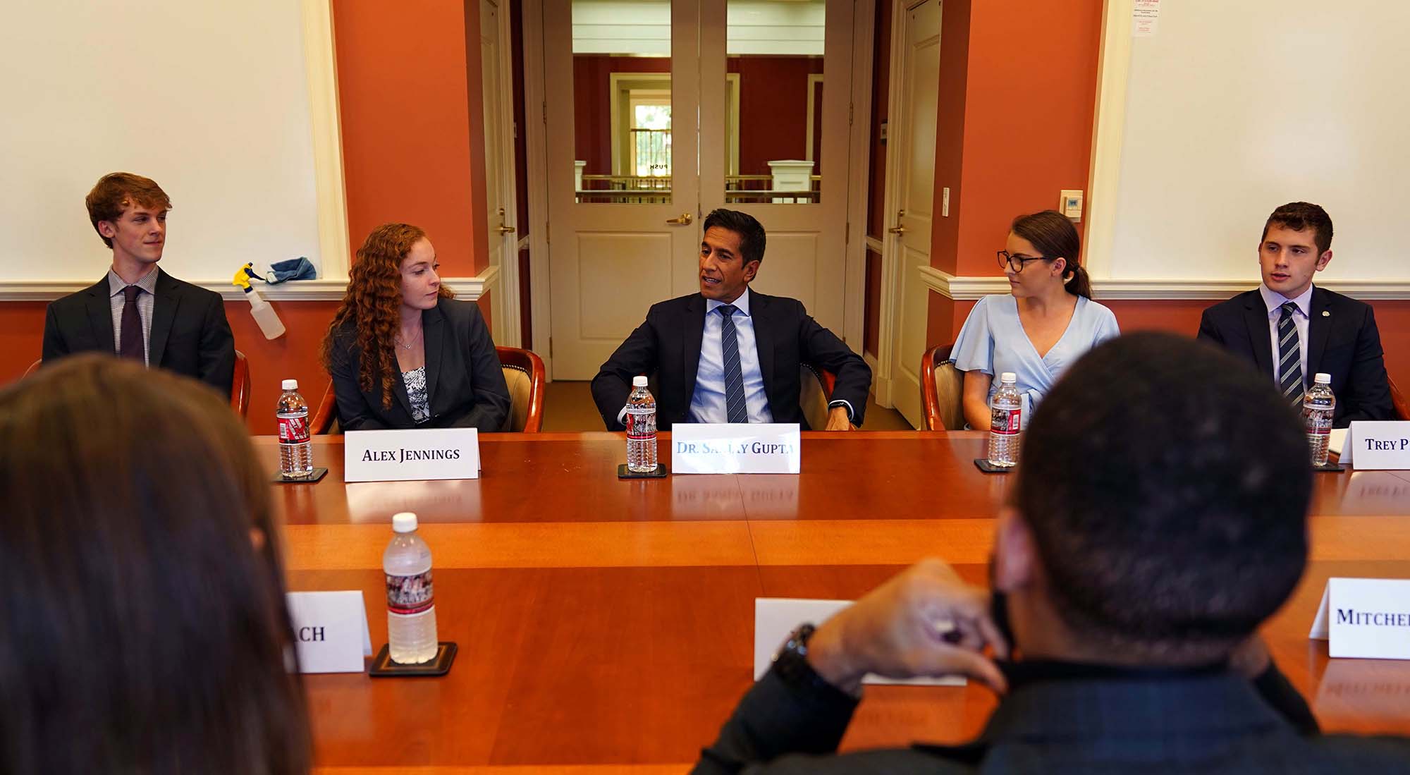 Dr. Sanjay Gupta talks with Farmer School students in a conference room.