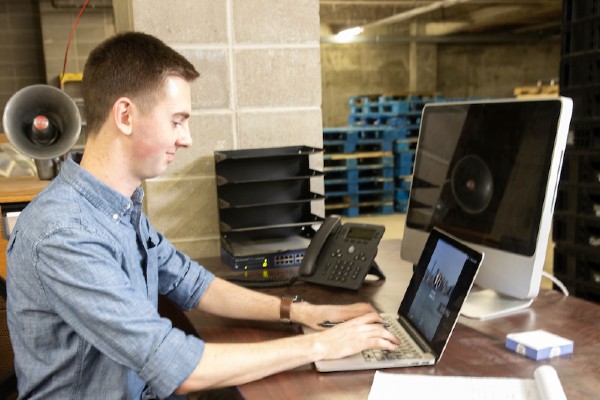 student working at laptop in warehouse