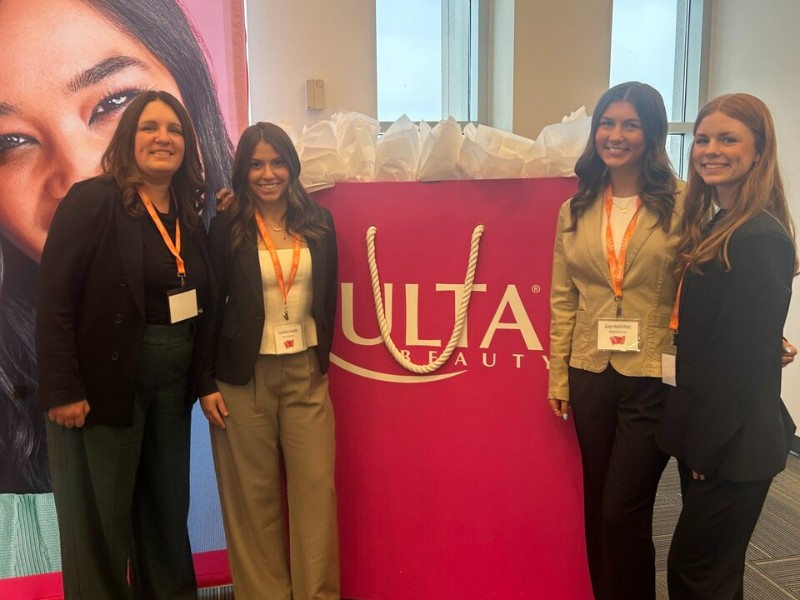 student talking with a Honda recruiter at event with Honda poster in backgroun