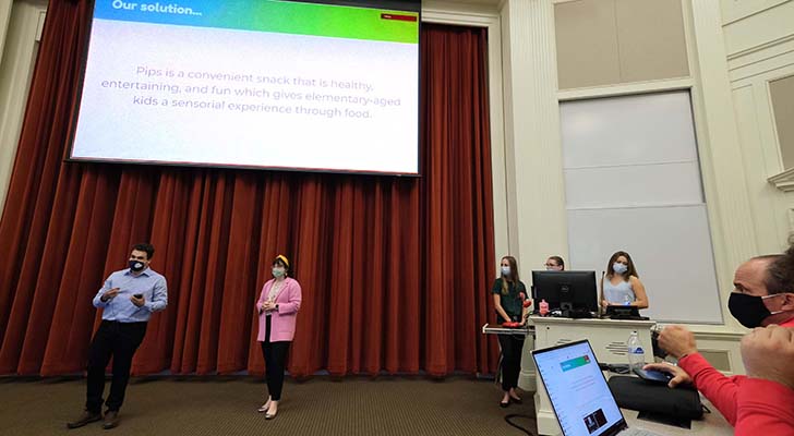 Students giving a presentation during masked srartup weekend