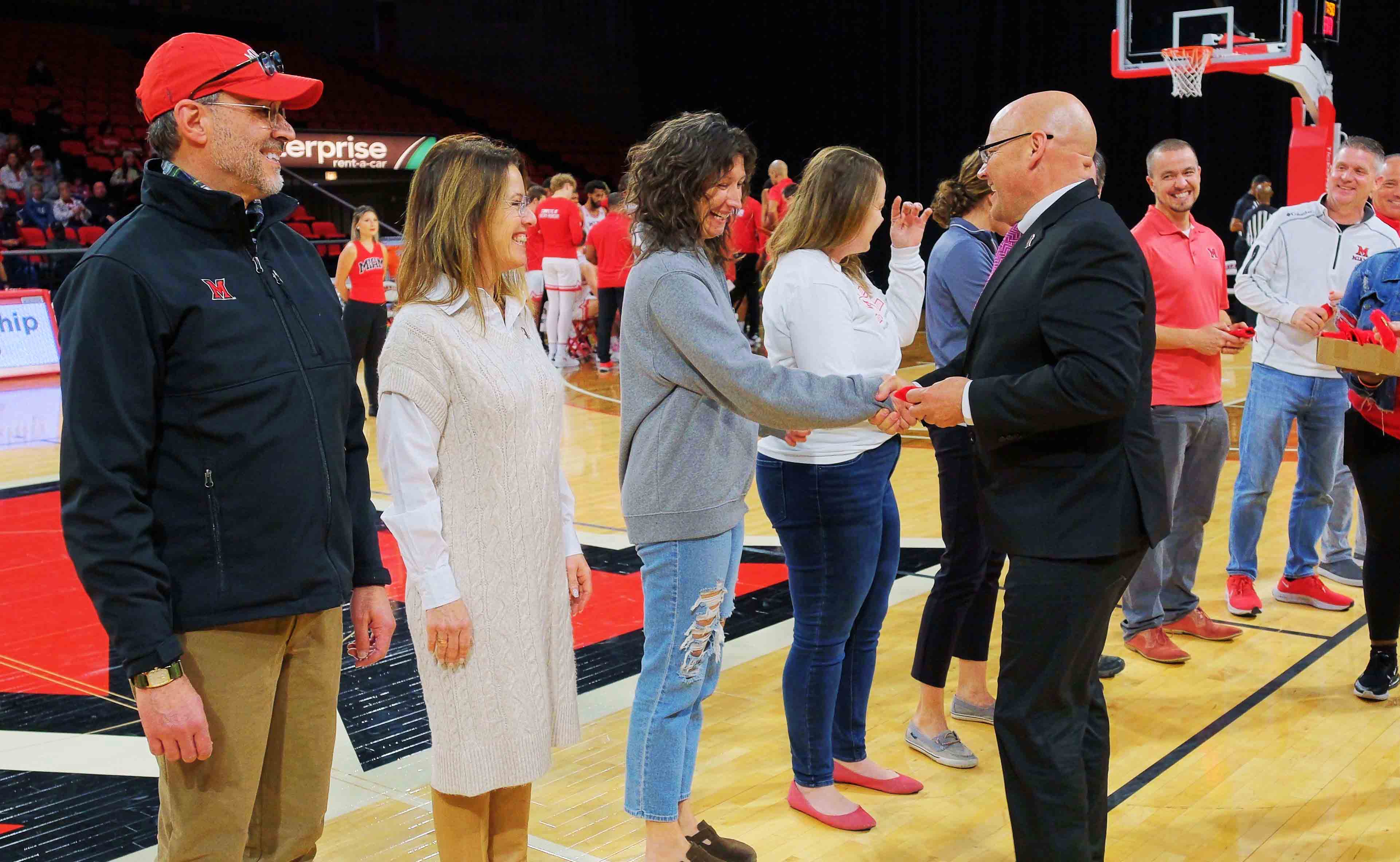 Greg Crawford shakes Beth Troy's hand after giving her the President's Medal.