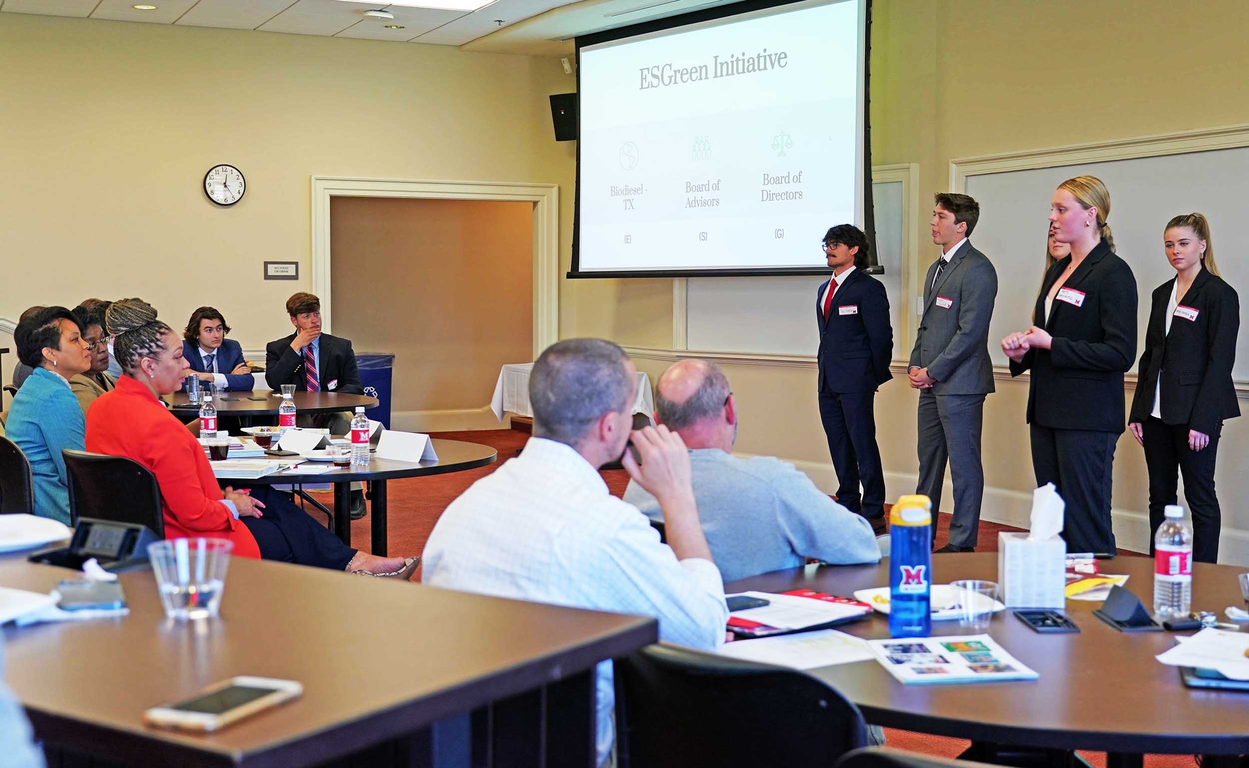 Next Gen Fuel execs (left) listen as FYIC students (right) make their presentation