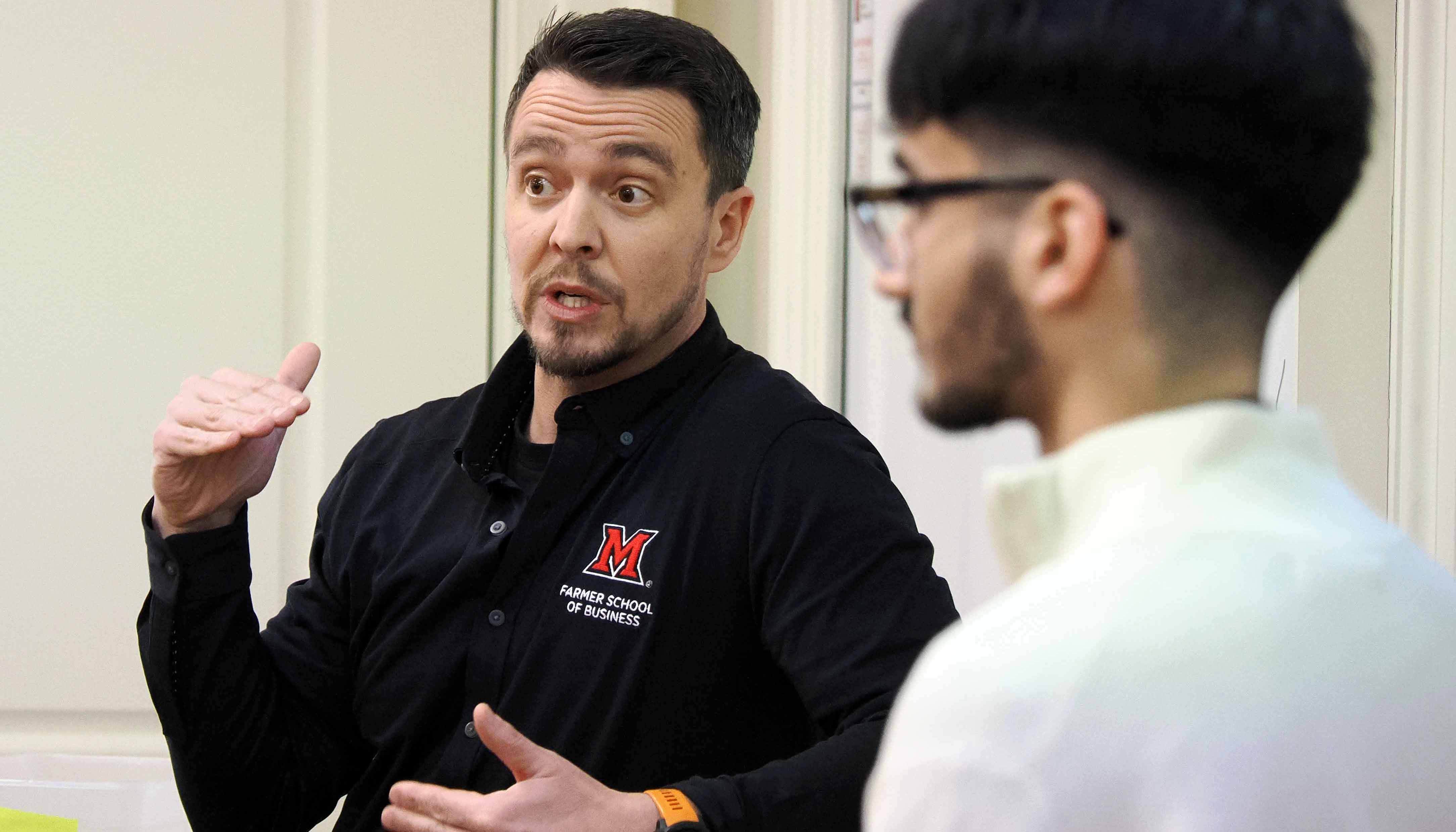 Geoff Zoeckler talking to a presenting student