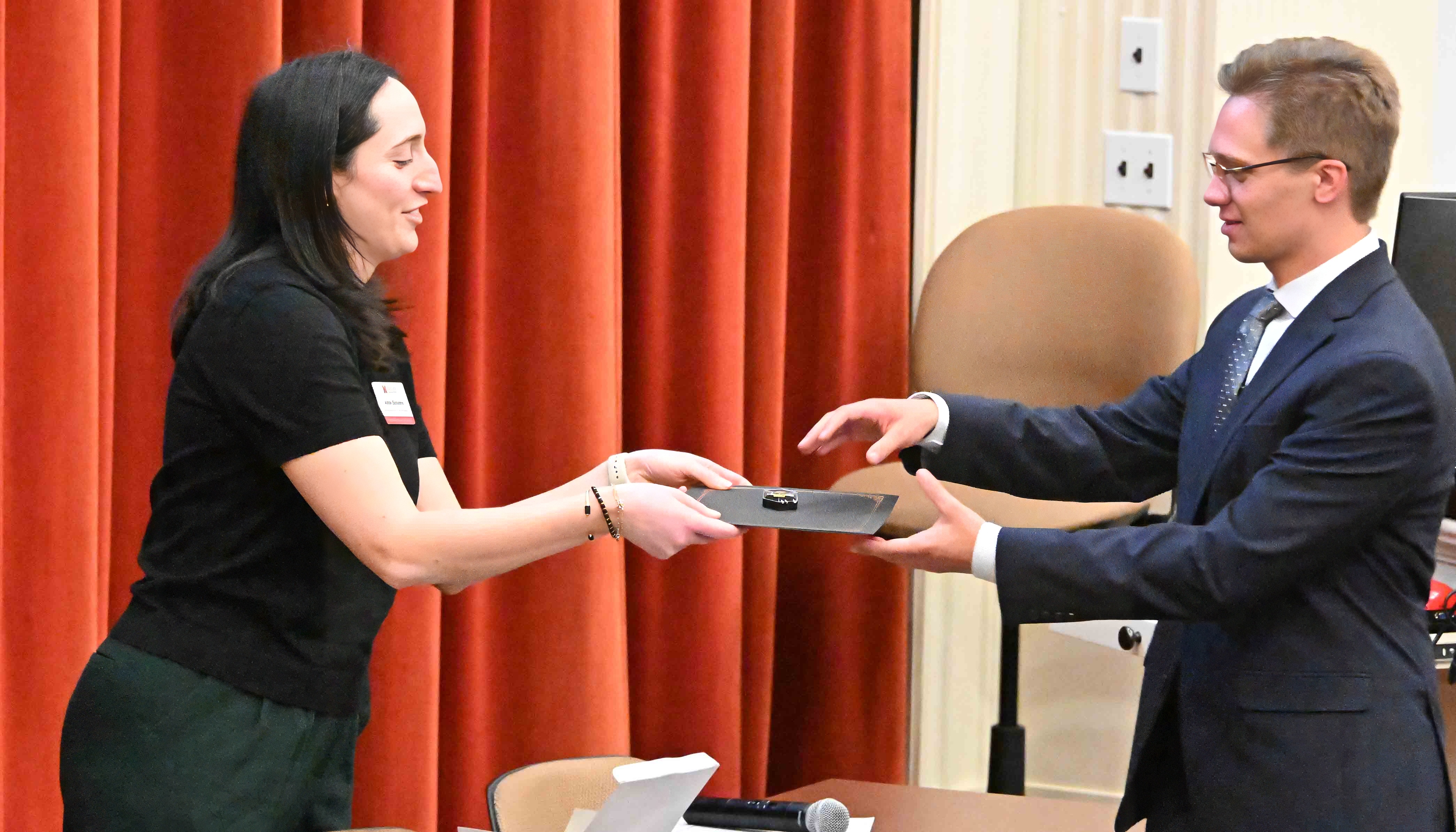 Student recieves pin and certificate
