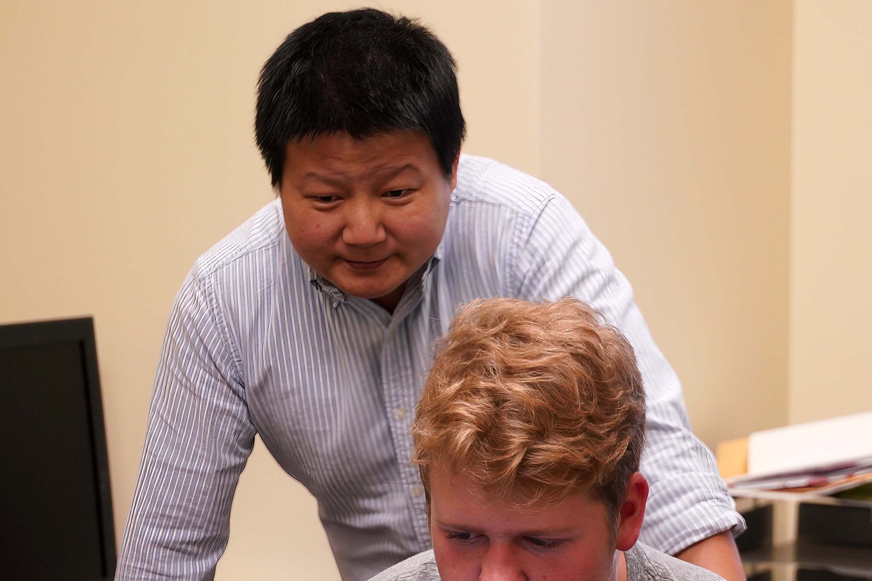 Jay Shan talking with a student in his office