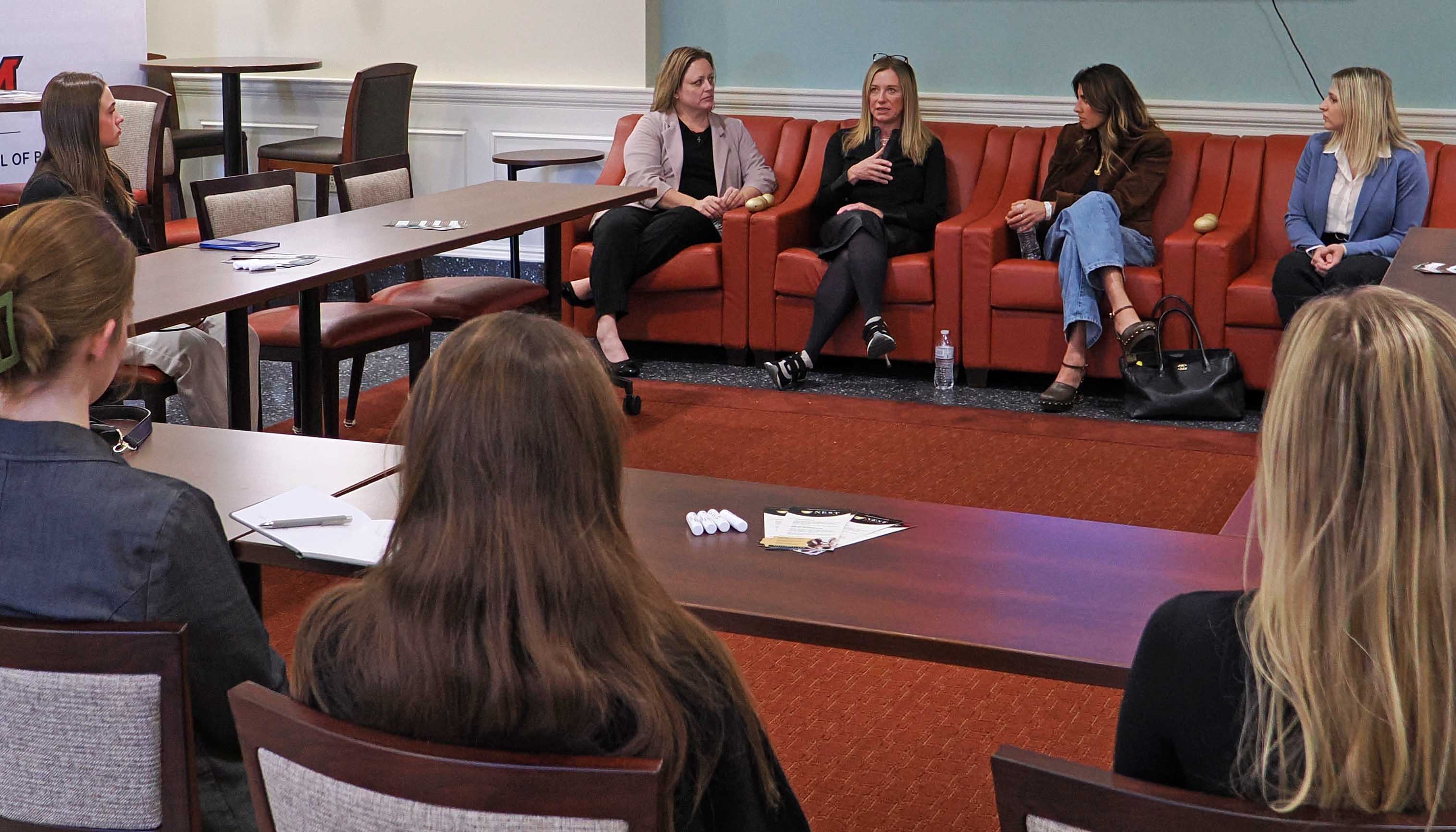 Lisa Rowe talks to students as other panelists listen