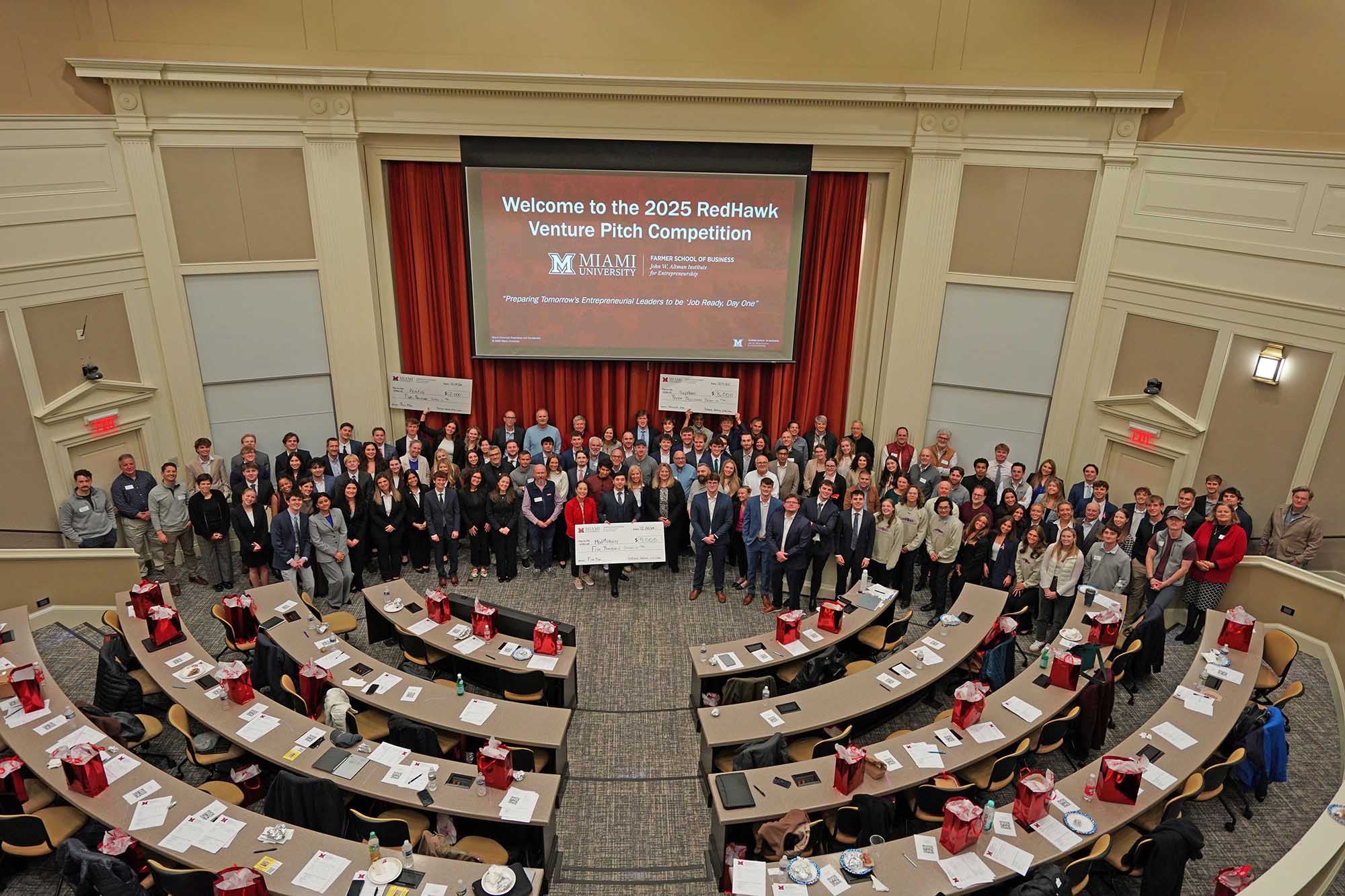 Group photo at the 2025 RedHawk Venture Pitch Competition featuring participants and judges gathered in a lecture hall, holding a large check.