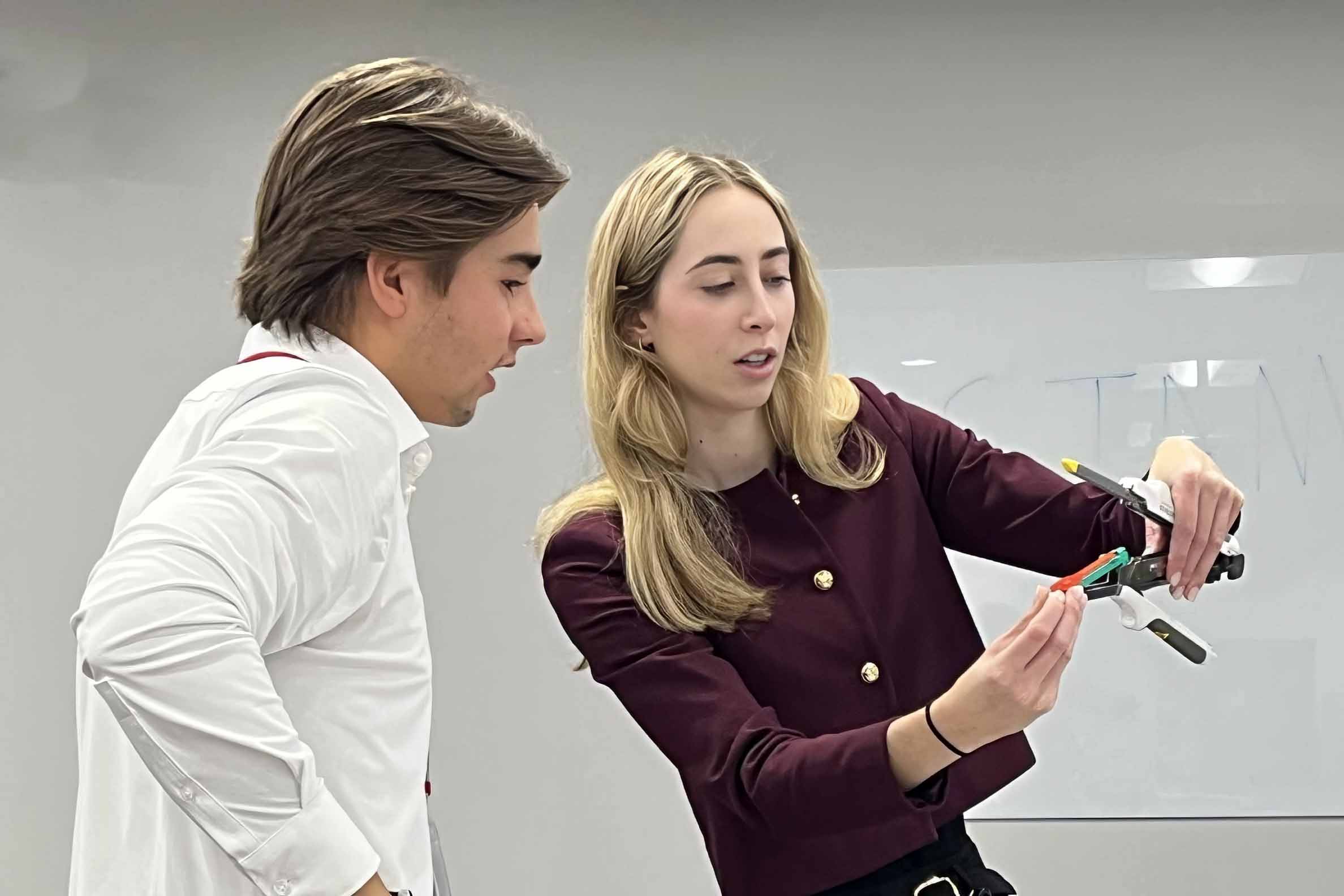 An executive shows a student how to work a piece of medical equipment