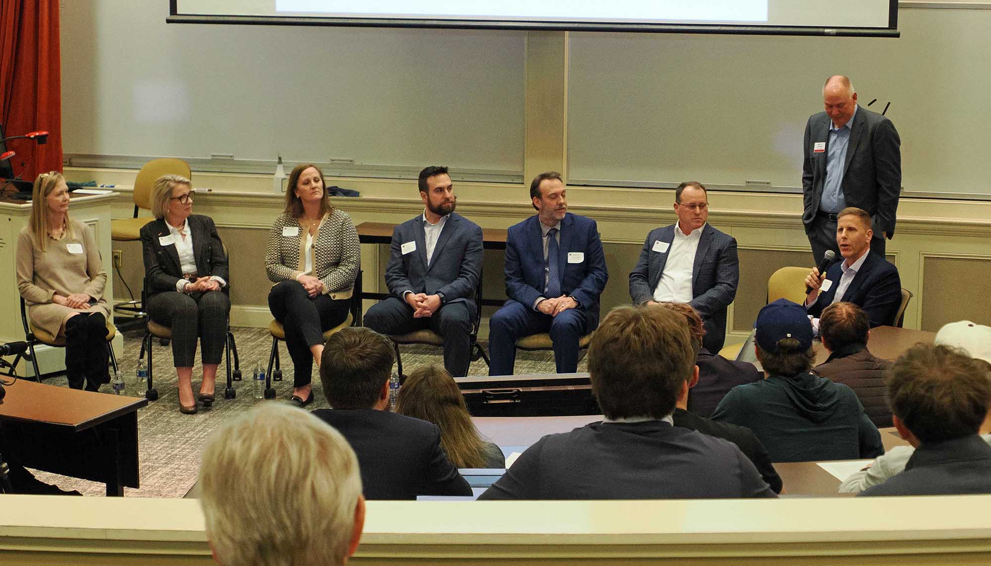 Panel discussion featuring industry professionals seated on a stage, addressing an audience during a speaker event.