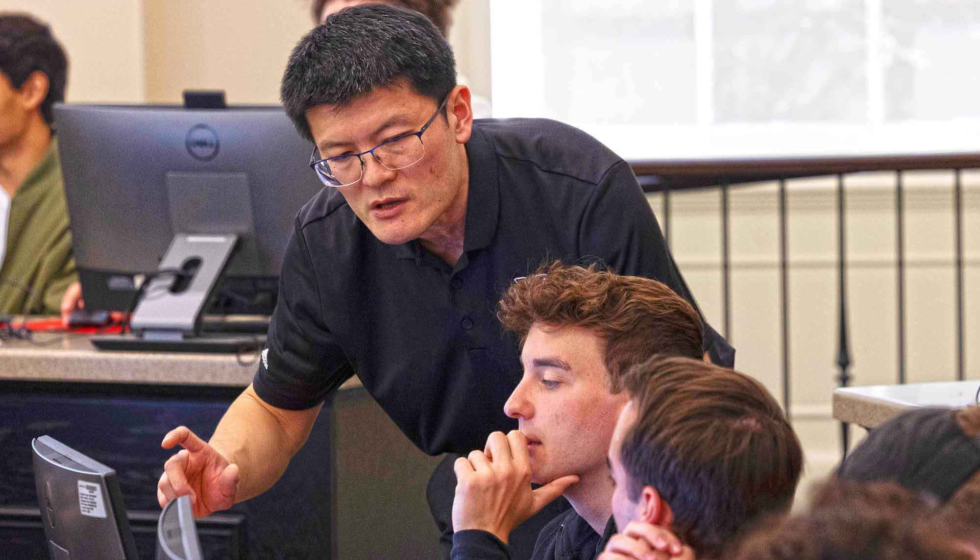 Xi Liu talking with students during class