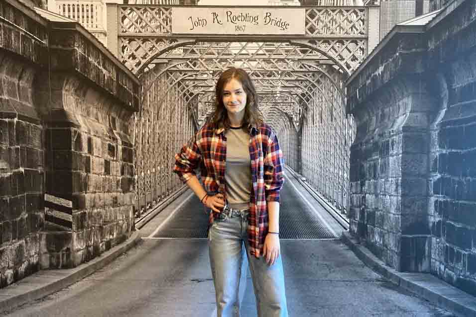 Lia Pistole in front of an image of the Roebling Bridge