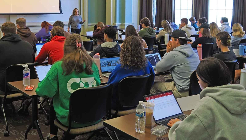 students in business leadership class sitting at desks facing screen