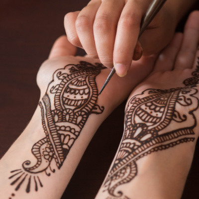 henna art displayed on a person's forearms, wrists, and hands