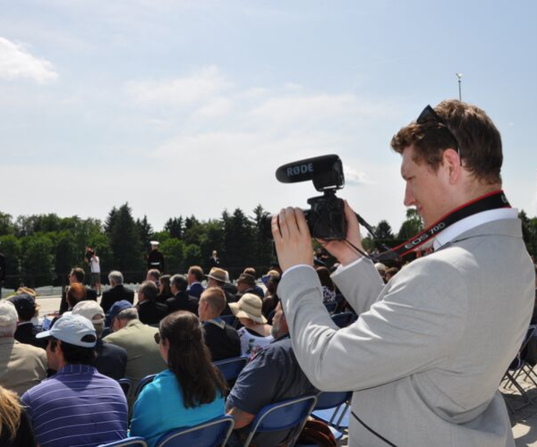 A student video shoot an event holding his camera