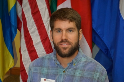award winner poses in front of flags